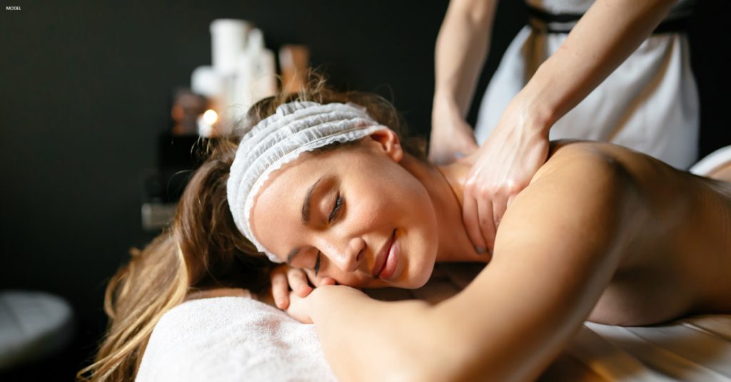 Young woman on lying on massage table getting shoulders massaged