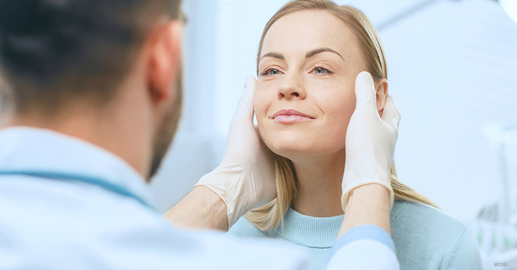 A woman appears happy with her jawline in her post treatment examination.