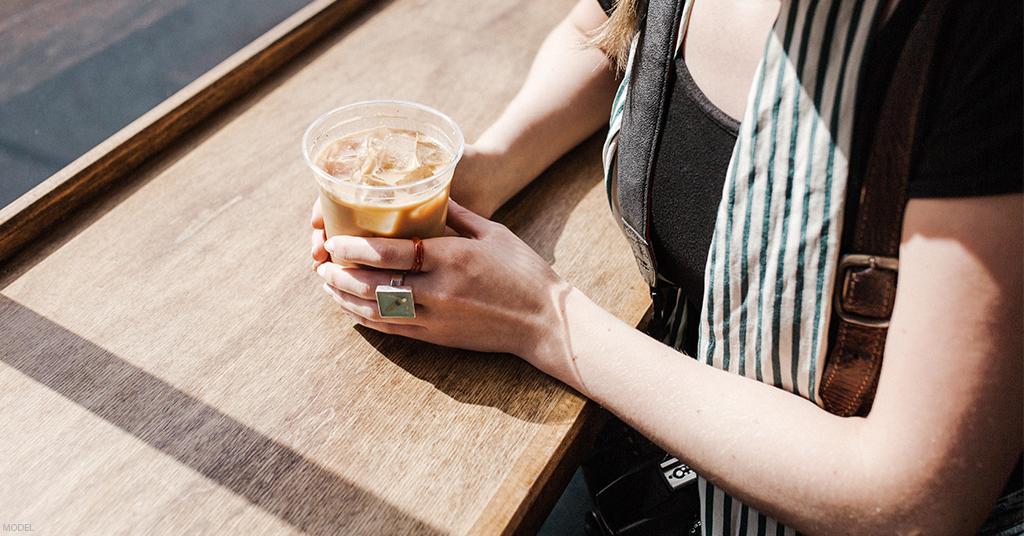 A woman enjoys coffee after receiving an arm lift.