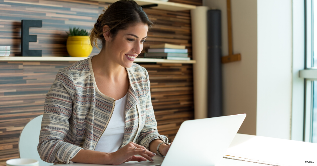 Woman smiling during a Zoom meeting from her desk at home